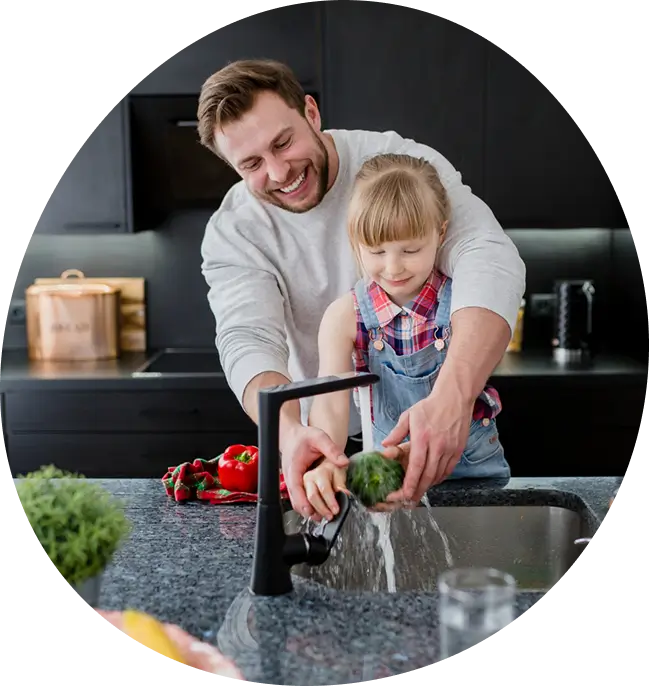 Family using hydrogen filtration at the kitchen sink, showing how Water Pure Texas integrates with daily life