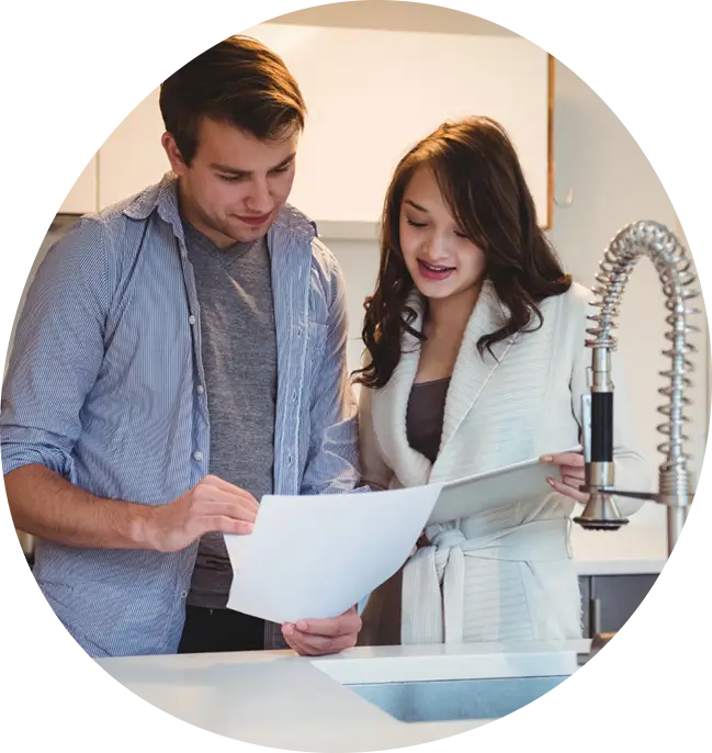 Man and woman reviewing a water quality report at the kitchen sink during a Water Pure Texas in-home consultation