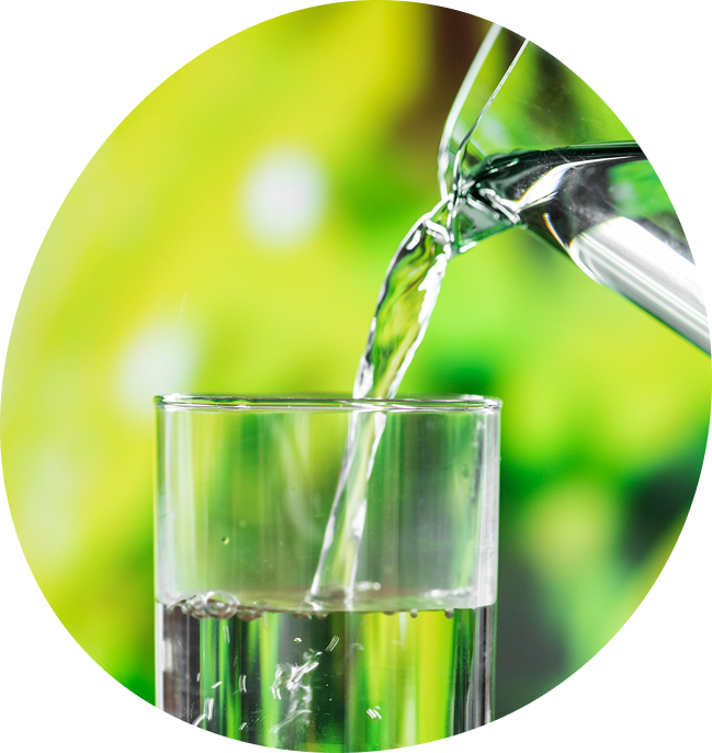 Clean filtered well water being poured into a glass, illustrating the results of a Water Pure Texas whole-home system